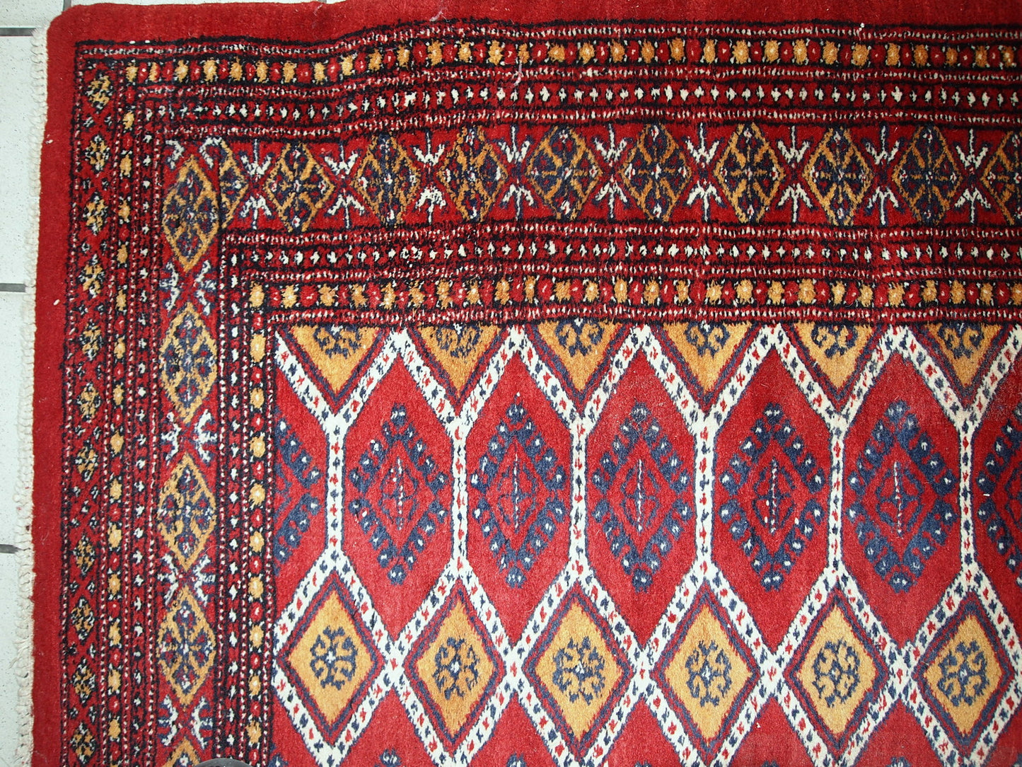 Vintage Uzbek Bukhara rug in red and yellow wool. The rug is from the end of 20th century in original good condition.