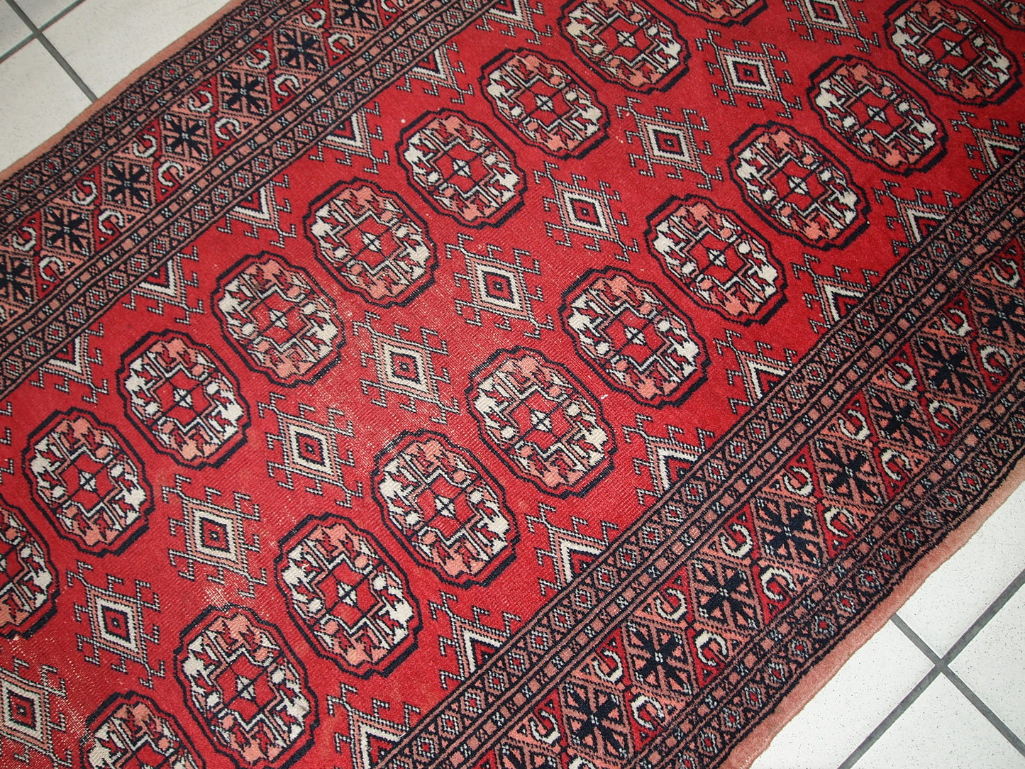 Handmade vintage Uzbek Bukhara runner in original condition, it has some age wear. The rug made in soft wool in the middle of 20th century.
