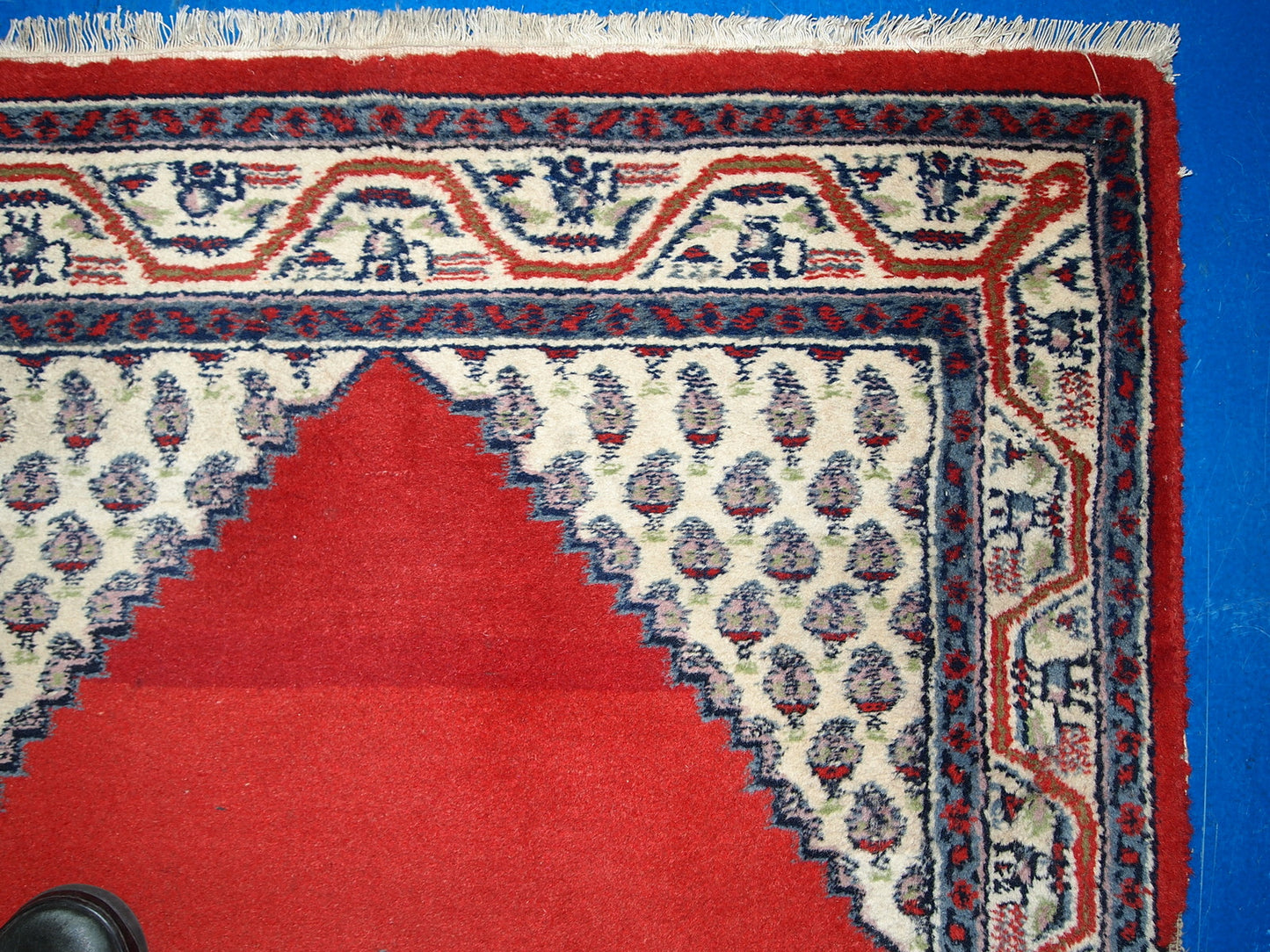 Vintage handmade Indian rug from the end of 20th century. The rug is in original good condition in red and beige wool.