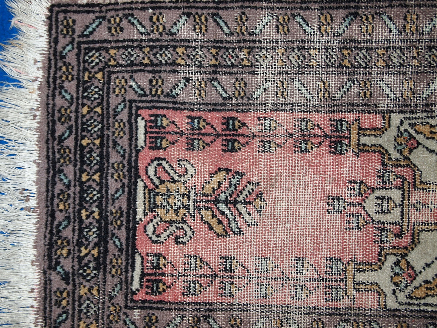 Vintage handmade Uzbek Bukhara praying mat in distressed condition. The rug is from the end of 20th century.
