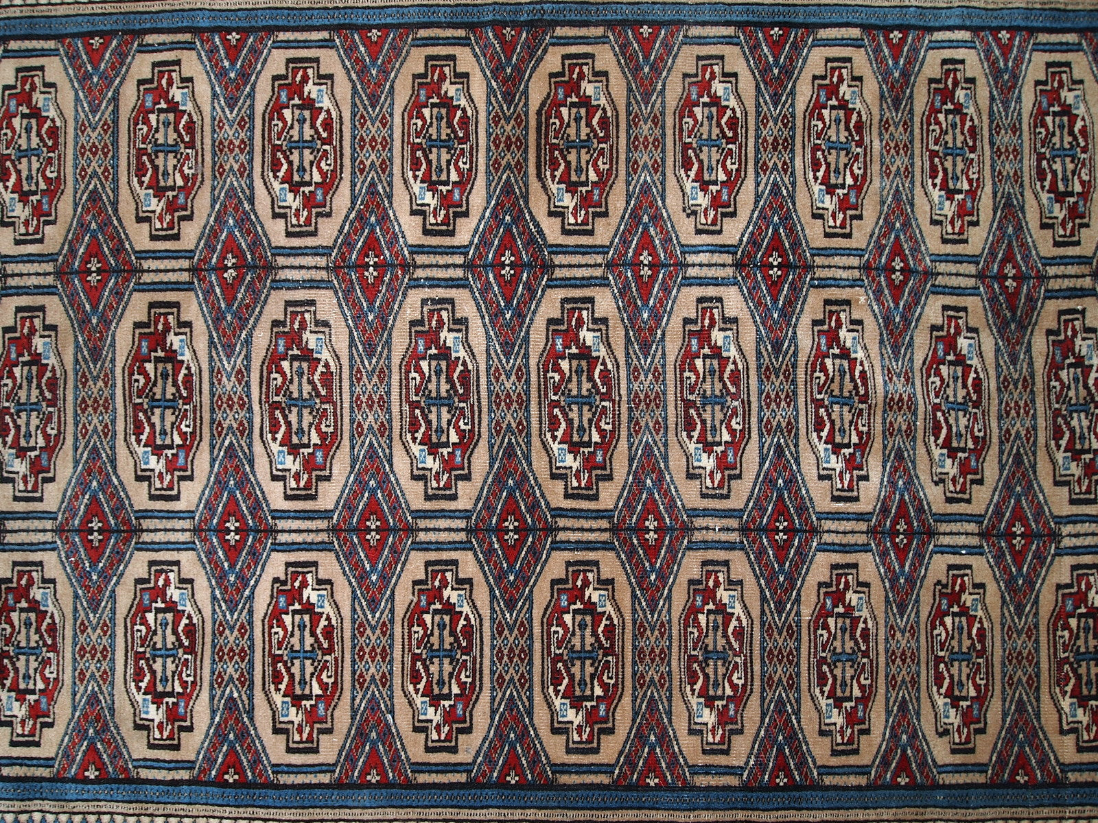 Handmade vintage Uzbek Bukhara rug in original good condition. The rug is from the middle of 20th century in brown and burgundy shades.