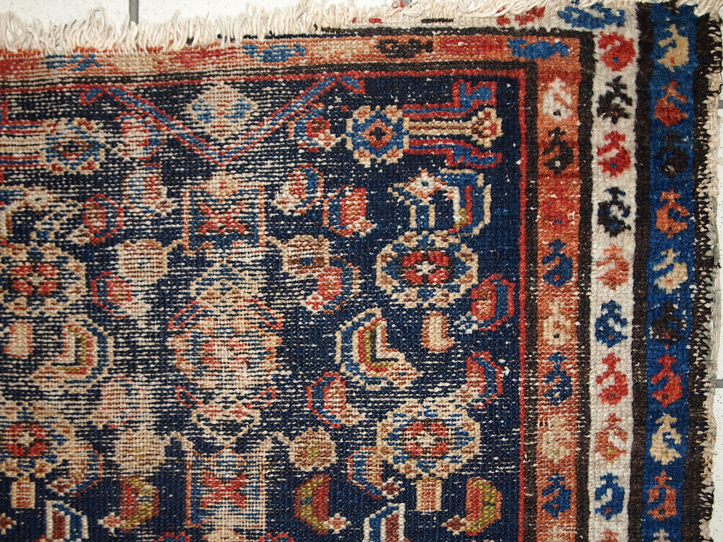 Handmade antique Middle Eastern rug in traditional design. The rug is from the beginning of 20th century in distressed condition.