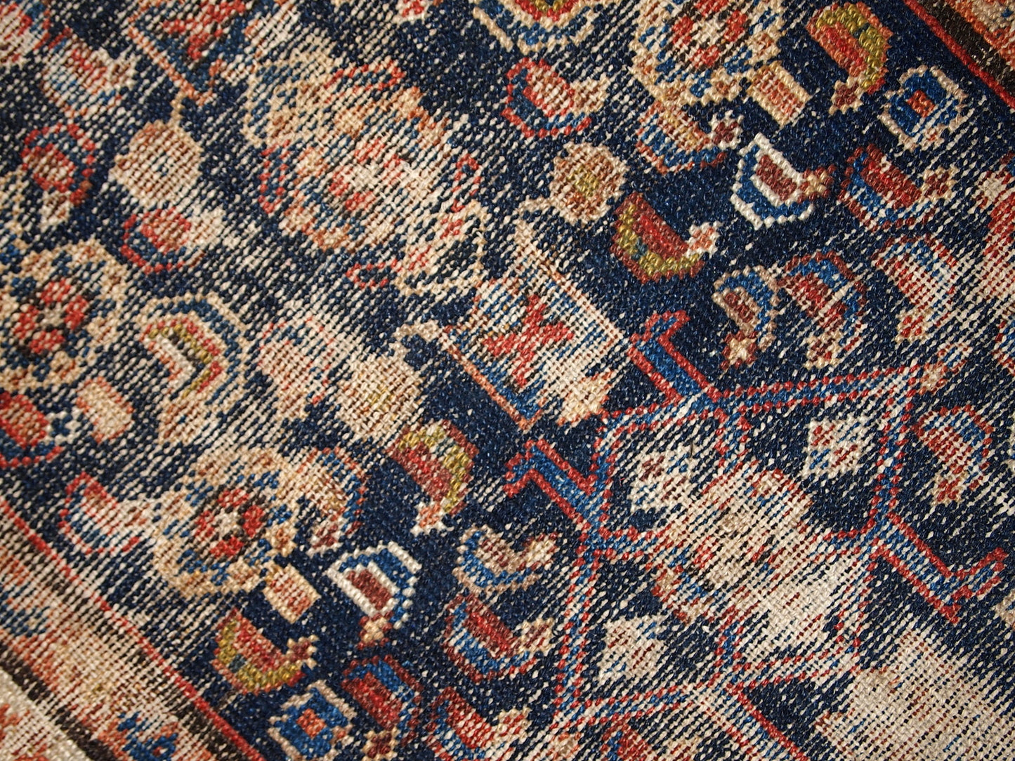 Handmade antique Middle Eastern rug in traditional design. The rug is from the beginning of 20th century in distressed condition.