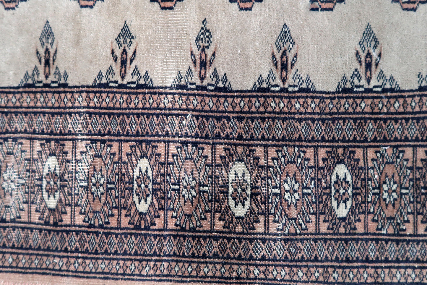 Handmade vintage Uzbek Bukhara distressed runner in traditional design. The rug is from the end of 20th century made in wool.