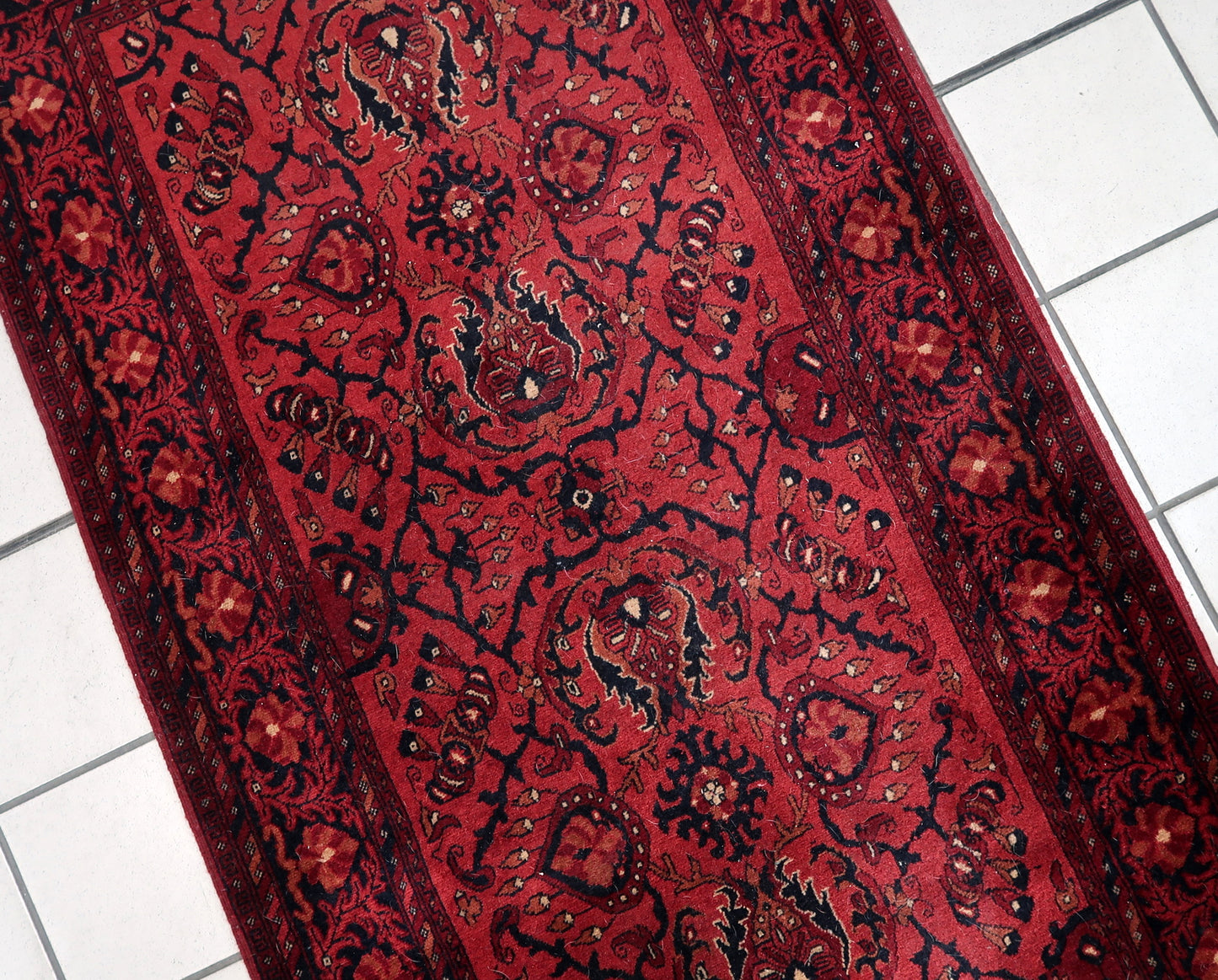 Handmade vintage Afghan Ersari runner in red color. The rug has been made in wool in the end of 20th century. It is in original good condition.