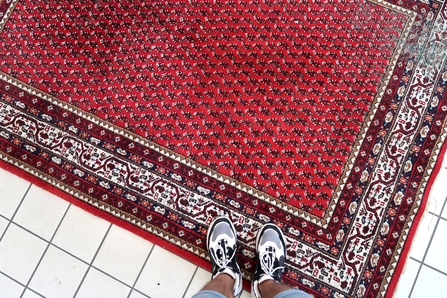 Handmade vintage Indian Seraband rug in original condition, it has some age wear on the one end. The rug has been made in traditional pattern, it is from end of 20th century. The shades of the rug are mostly in red and white. All-over design will bring some modern look to your space. All dyes on this rug are natural. This is the type of rug woven in India to compete in the same market as rugs from Persia.