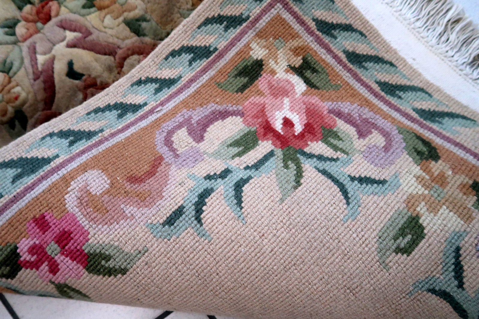 Handmade vintage Art Deco Chinese rug in beige, green and red colors. The rug is from the end of 20th century in original good condition. This rug has classic floral design with the touch of French style.