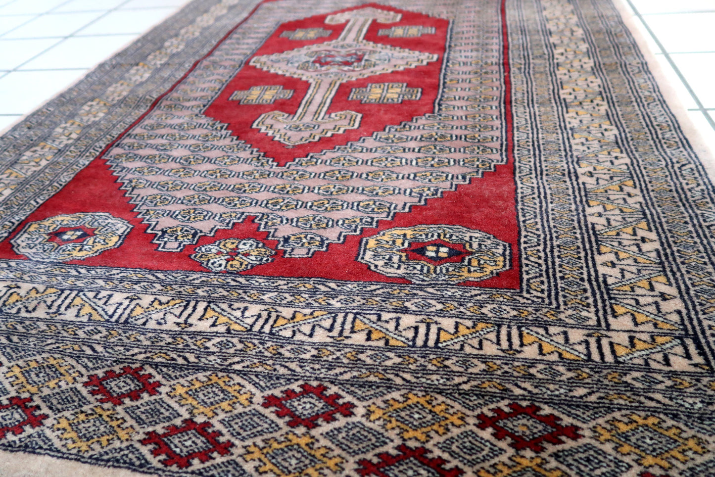 Handmade vintage Uzbek Bukhara rug in unusual design. The rug is from the end of 20th century. It is in original good condition.