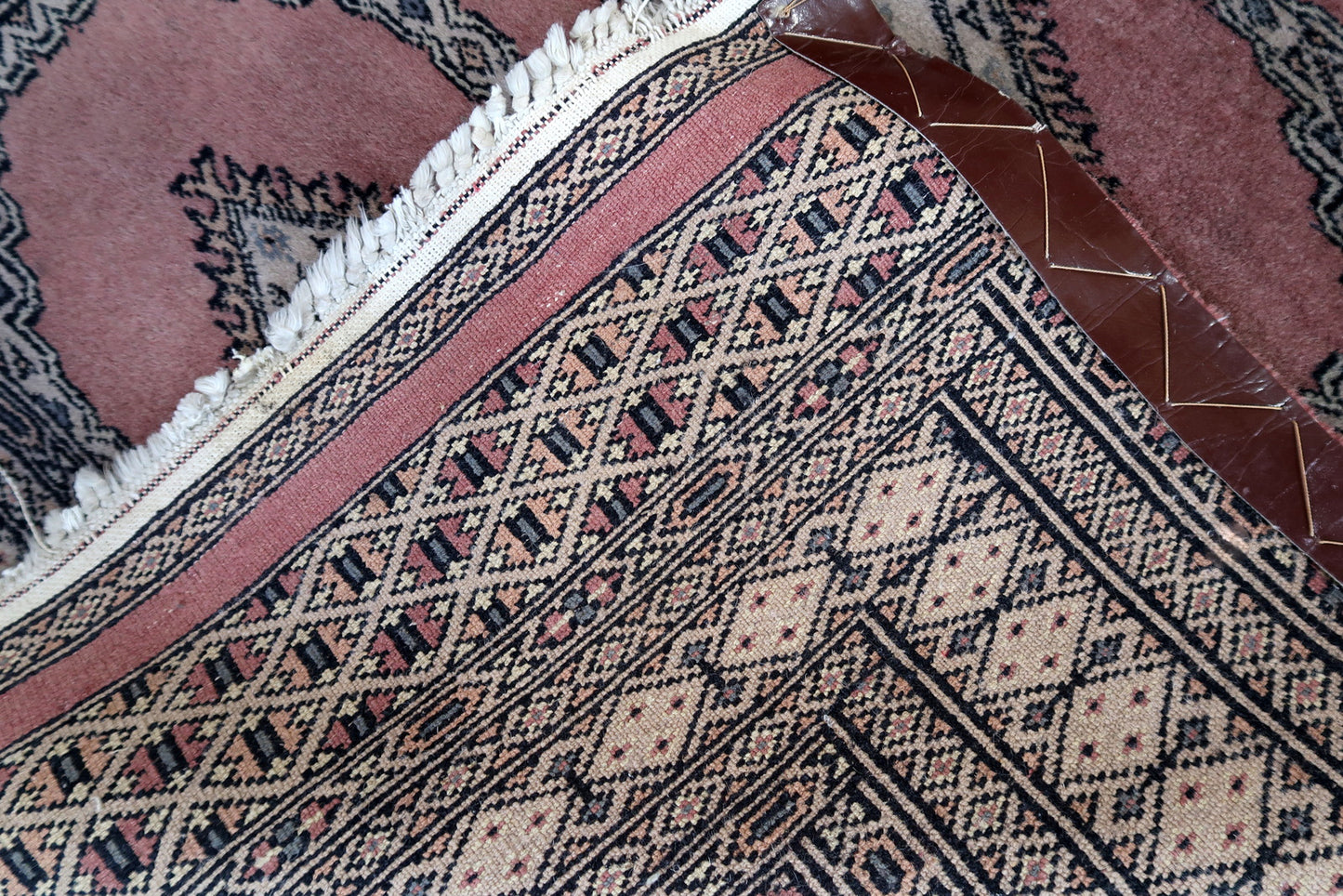 Handmade vintage Uzbek Bukhara rug in traditional design and pink wool. The rug is from the end of 20th century. It is in original good condition.