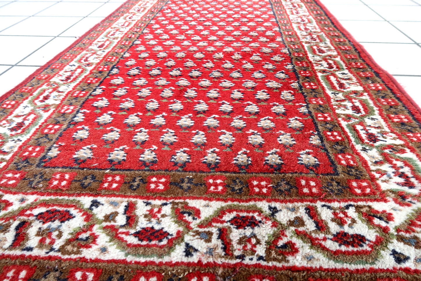 Handmade vintage Indian Seraband rug in red color and all-over design. The rug has been made in the end of 20th century. It is in good condition, has some signs of age.