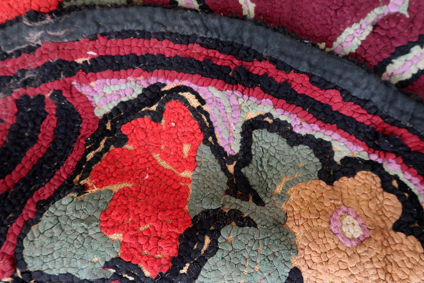 Handmade antique American Hooked rug in floral design and black background. The rug is from the beginning of 20th century. It is in good condition, has some old restorations.