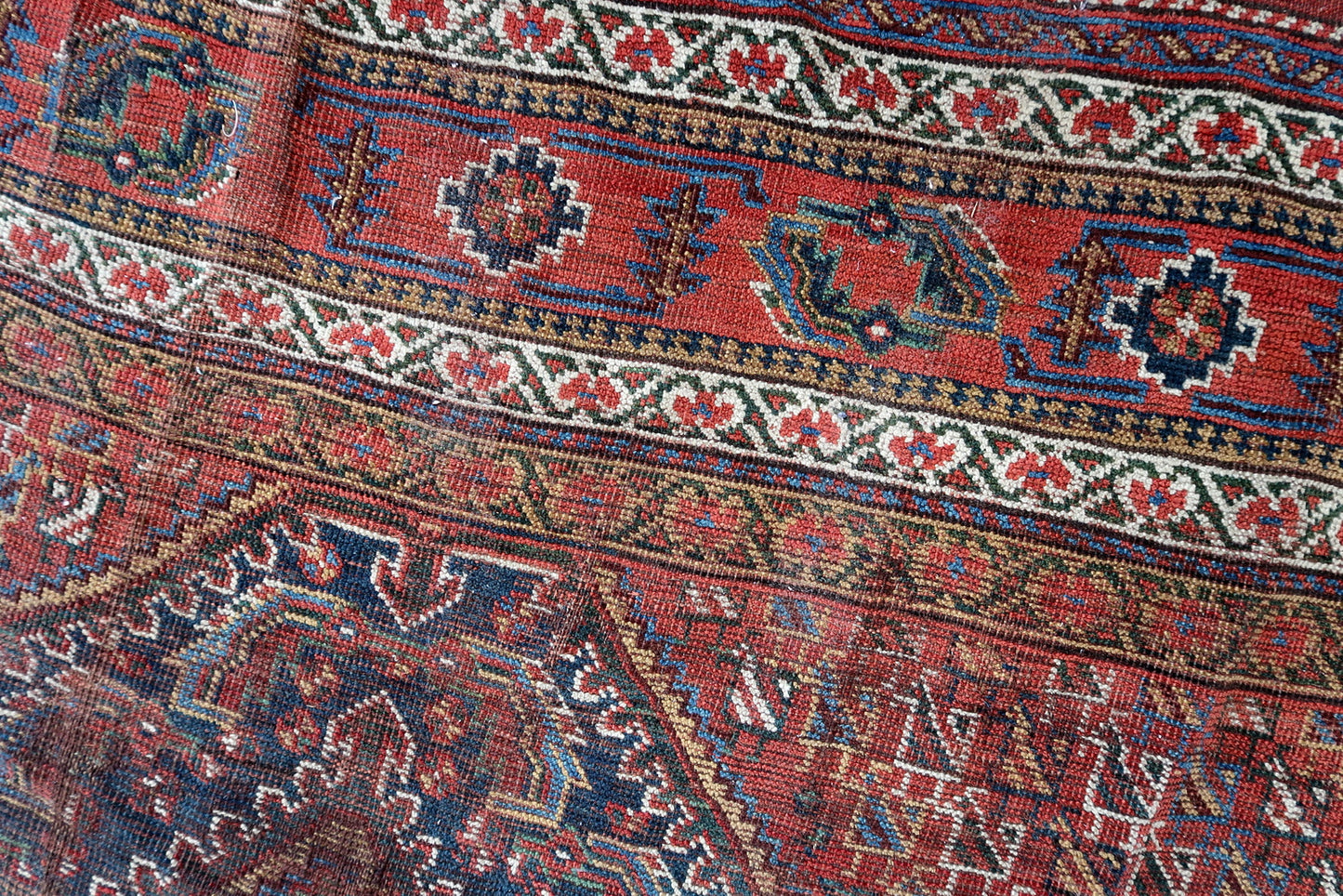 Handmade antique oversized Persian Khamseh rug in traditional design. The rug is from the end of 19th century in distressed condition.