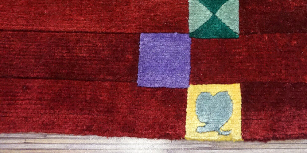 Handmade vintage Persian Gabbeh rug in bright red color and colorful geometric design. The rug is from the end of 20th century in original good condition.