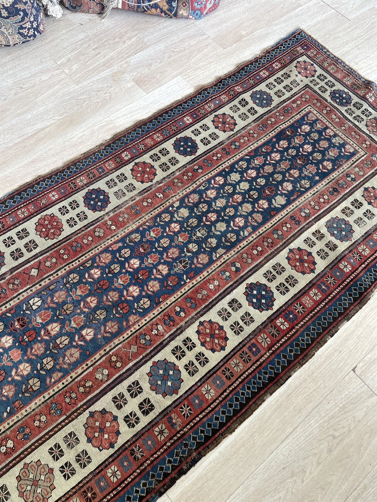 Full view of a circa 1880s Talish tribal rug with a deep indigo navy field, a wide natural ivory/camel main border with large medallions, and a teal-navy outer diamond reciprocal border.

