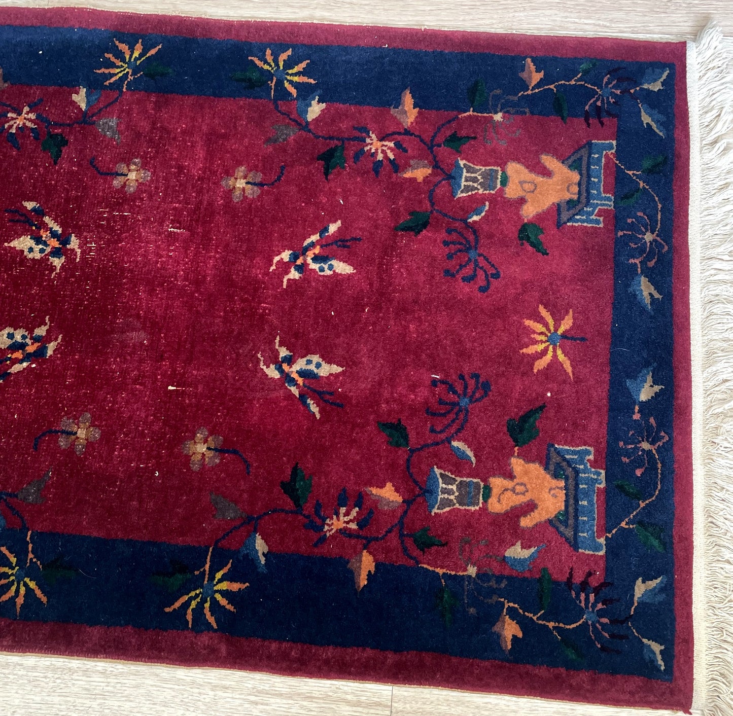 Antique Chinese rug measuring 2'11" × 4'10", hand-knotted circa 1920s in the Tianjin/Peking export tradition, with a largely open crimson field and scattered auspicious symbols.


