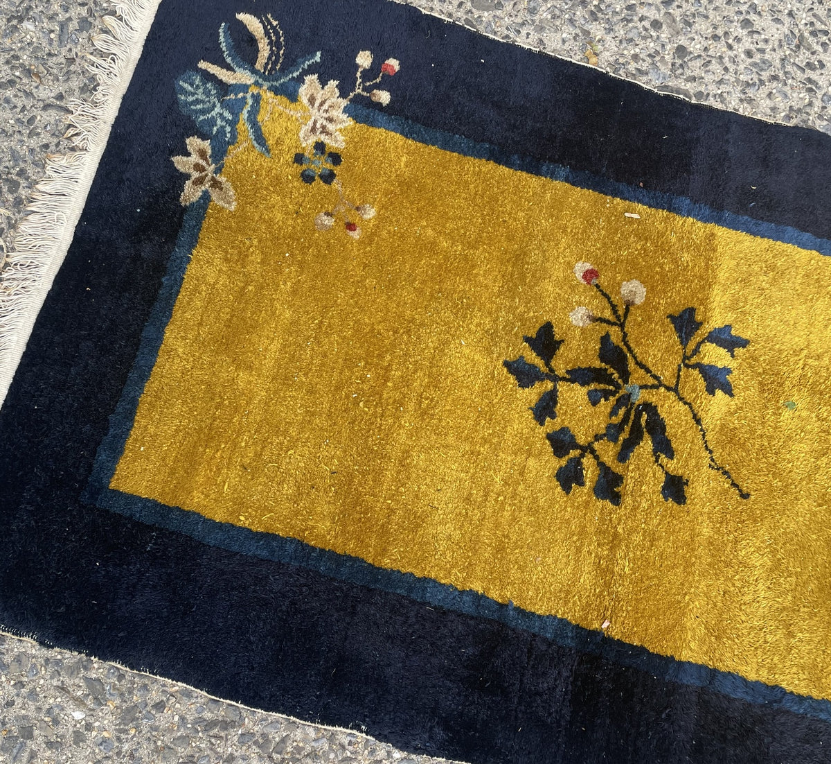 Asymmetric floral sprays in opposing corners of gold and navy rug 1B1007