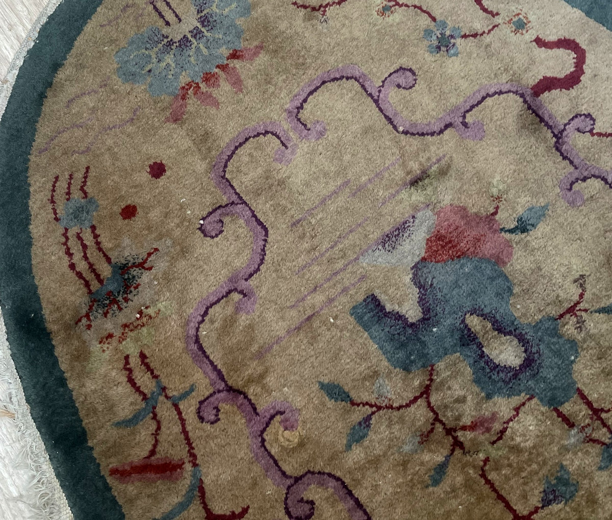 Close-up of reduced pile and surface marks above the central blue floral motif