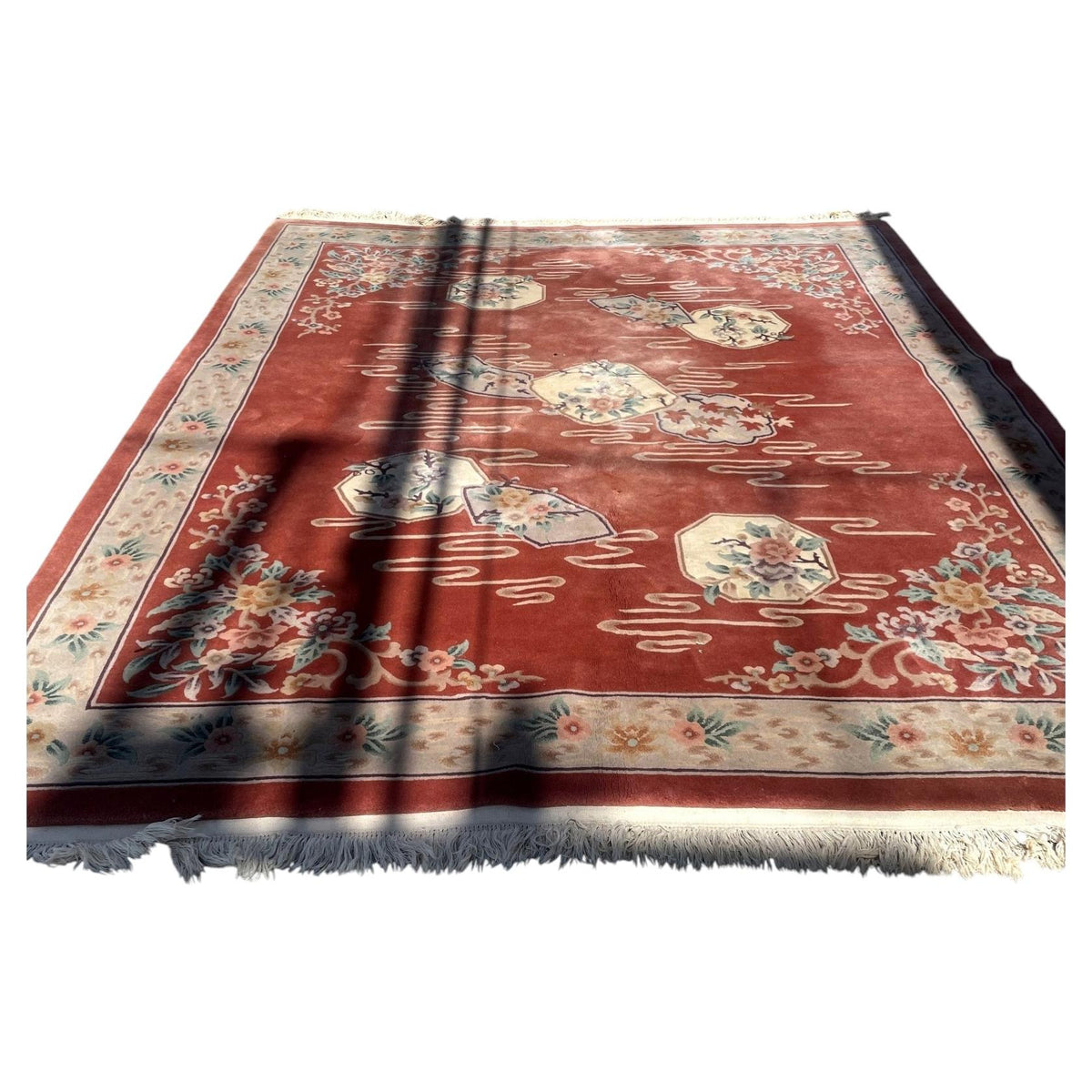 Full view of terracotta Chinese Art Deco wool rug 1B1010 with ivory floral panels and fringed end