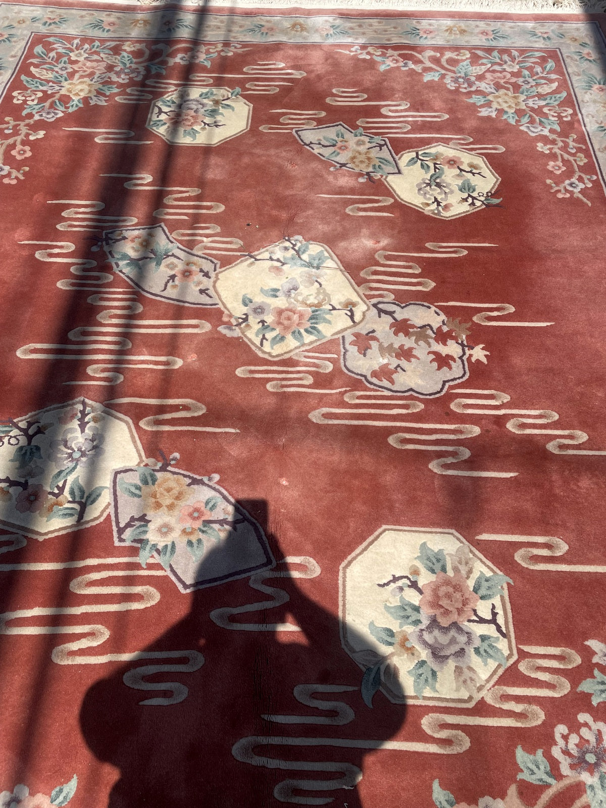Terracotta field with octagonal and fan-shaped floral panels and trailing ivory lines
