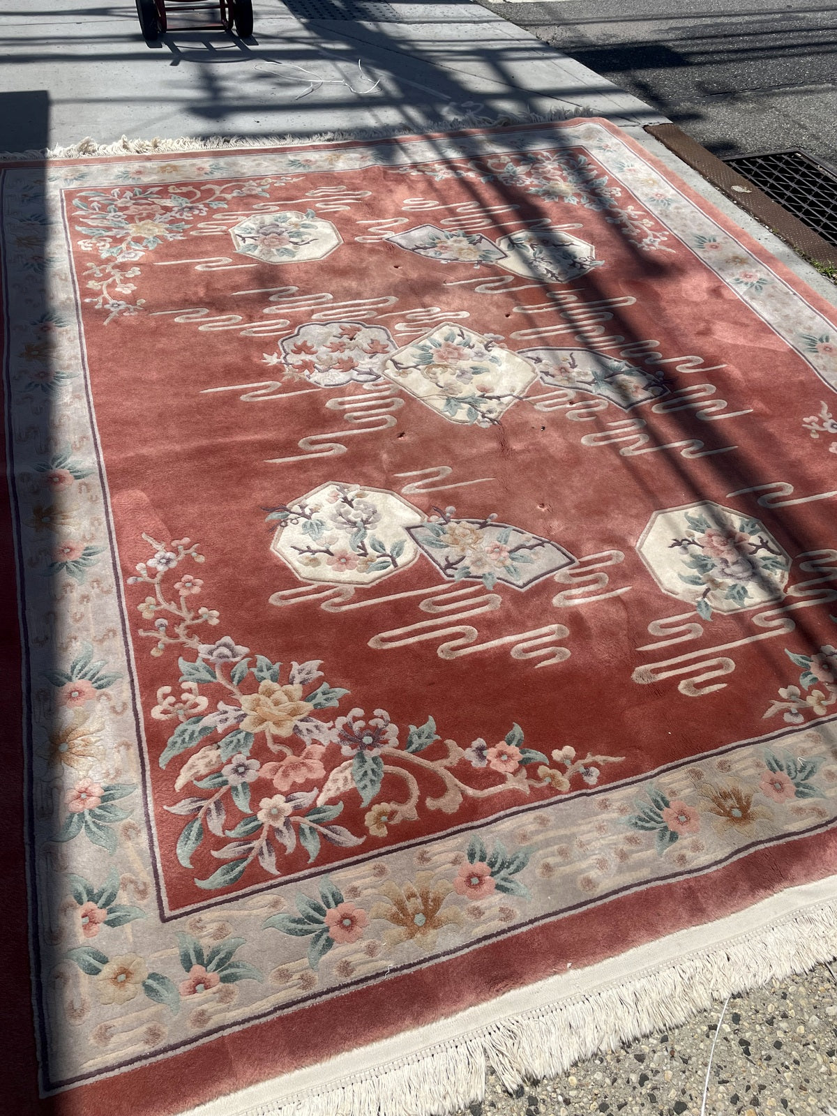 Full-length view of the terracotta rug showing its panel arrangement and broad pale border