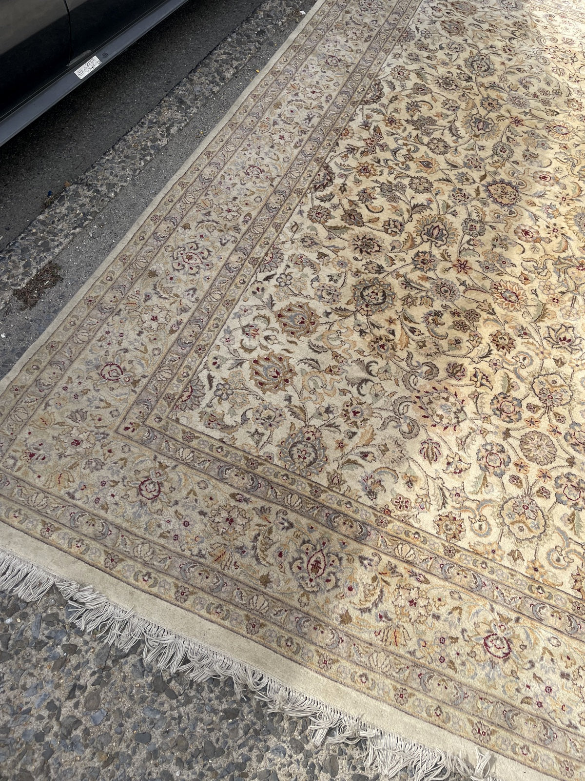 Angled corner view showing floral borders and uneven fringe