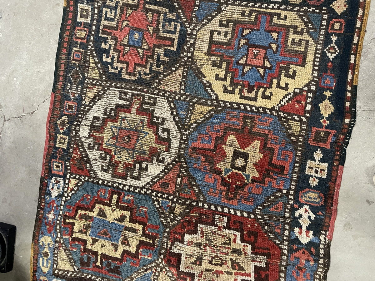Angled view of stepped medallions in red, blue, ivory and pale yellow