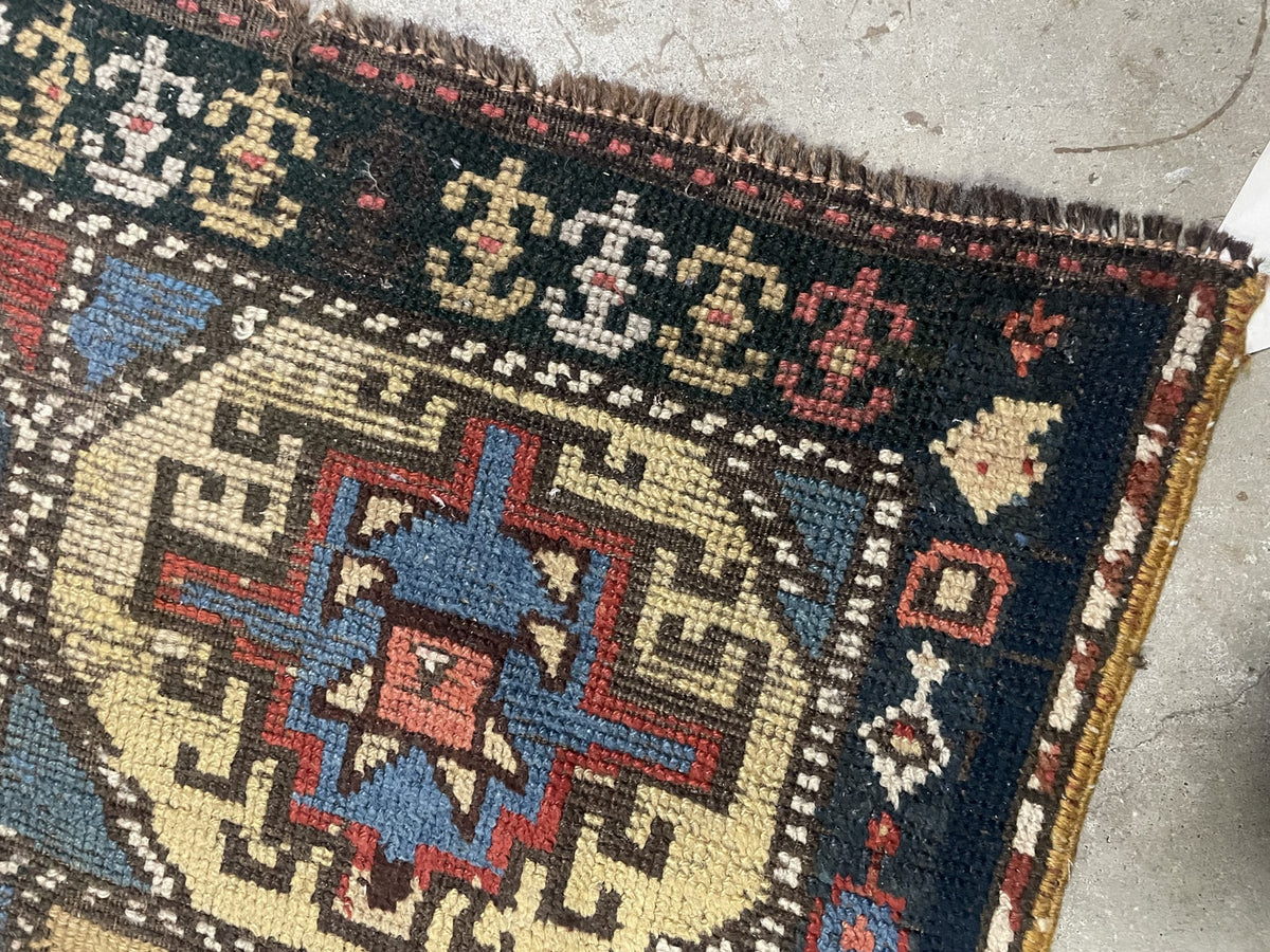 Frayed end beside navy border with ivory and yellow geometric ornaments
