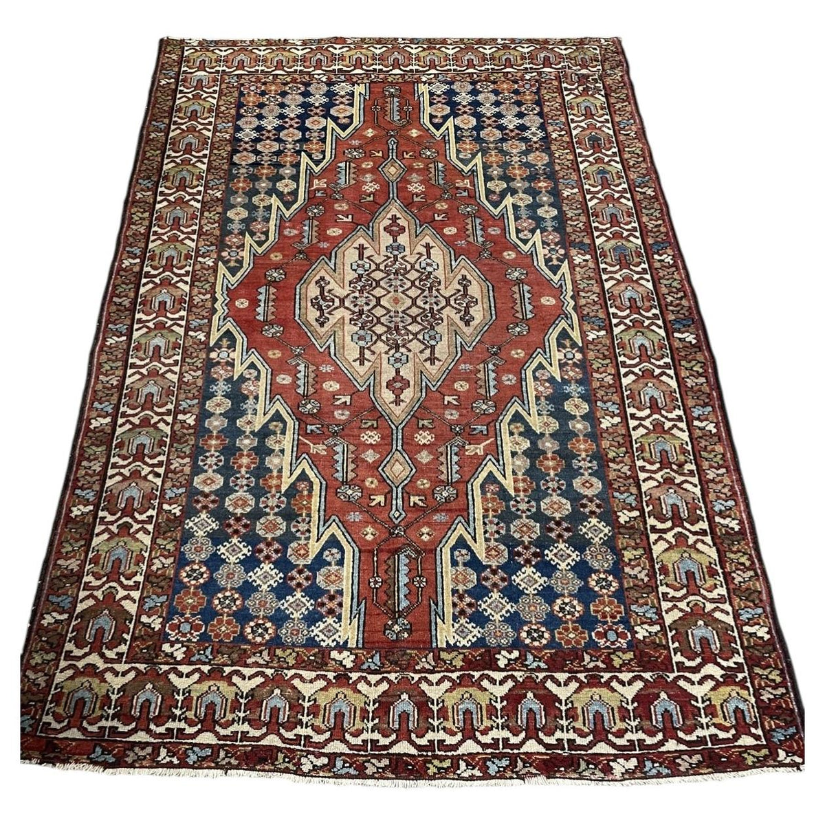 Antique wool rug 1B1018 with red field, pale medallion and deep blue side panels
