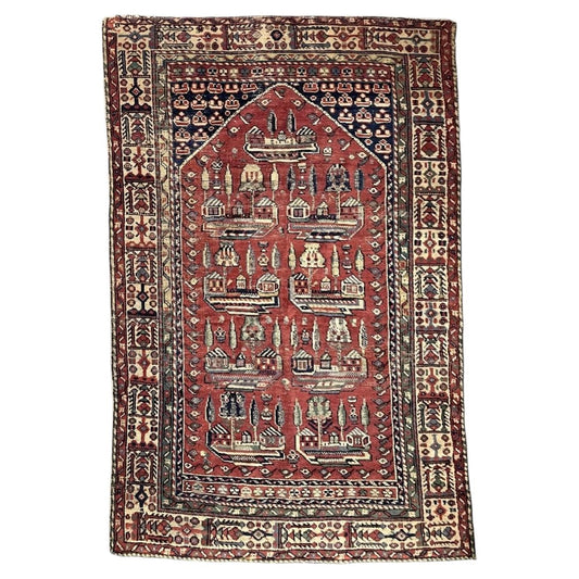Antique Turkish Ghiordes wool rug with red architectural field and ivory panelled border