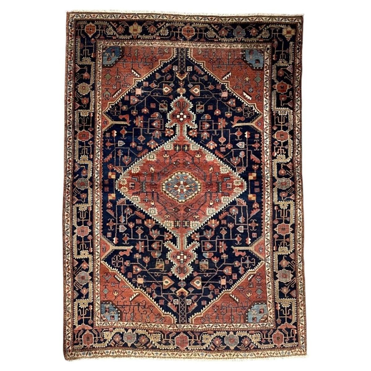 Antique navy wool rug with a coral diamond medallion and ivory outlines