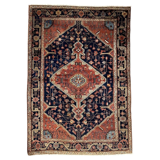 Antique navy wool rug with a coral diamond medallion and ivory outlines