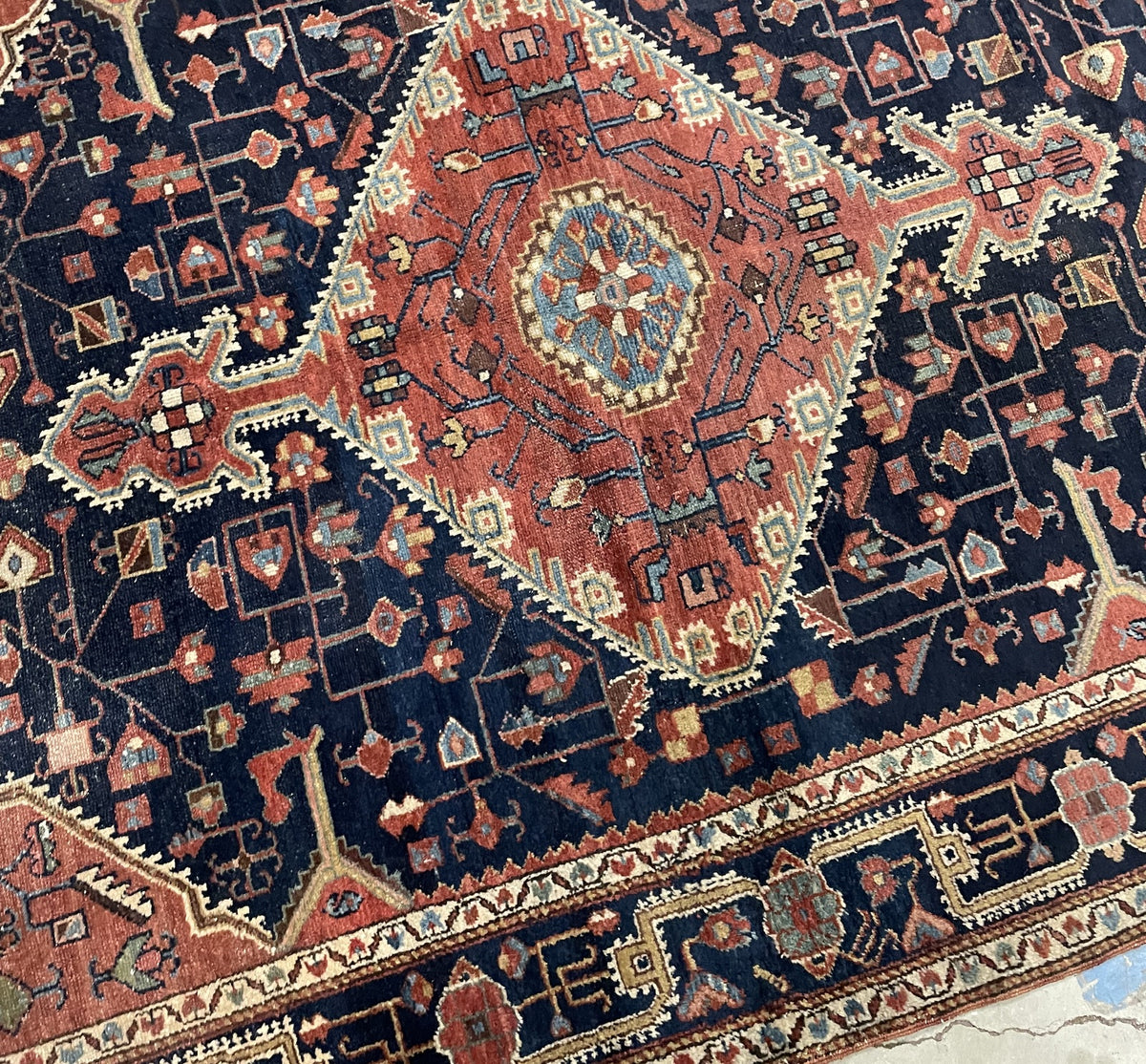 Detail of the hand-knotted medallion rug with coral and pale blue accents