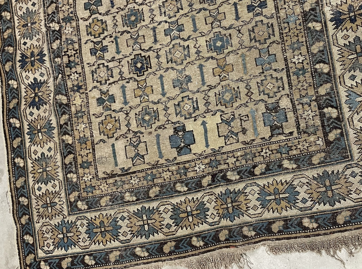 Muted blue and pale gold motifs across the ivory field