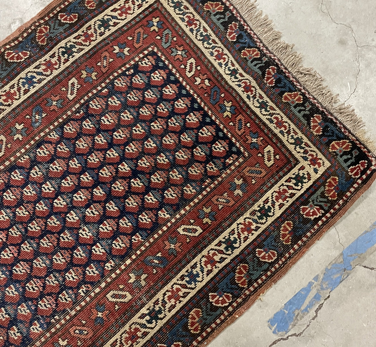 Worn end section with rust-red geometric and ivory botanical borders