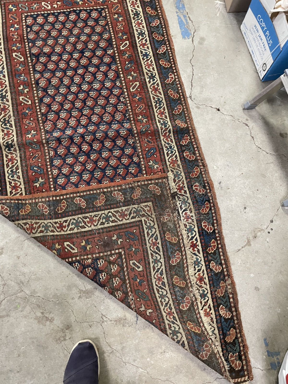 Localised wear exposing the weave around the field and borders
