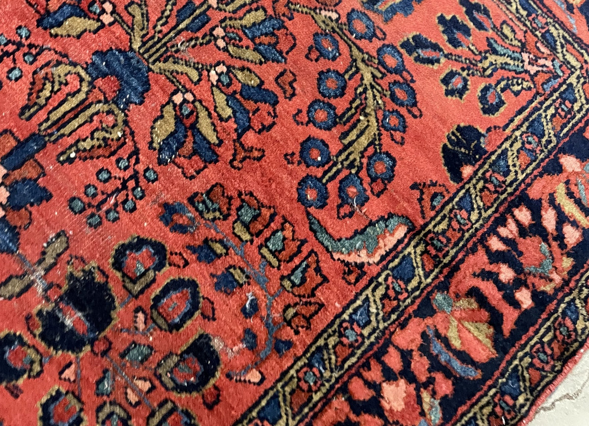 Coral floral field with low uneven pile and visible wear
