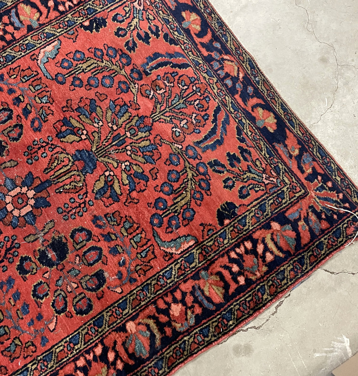 Worn end and navy border surrounding the coral floral composition