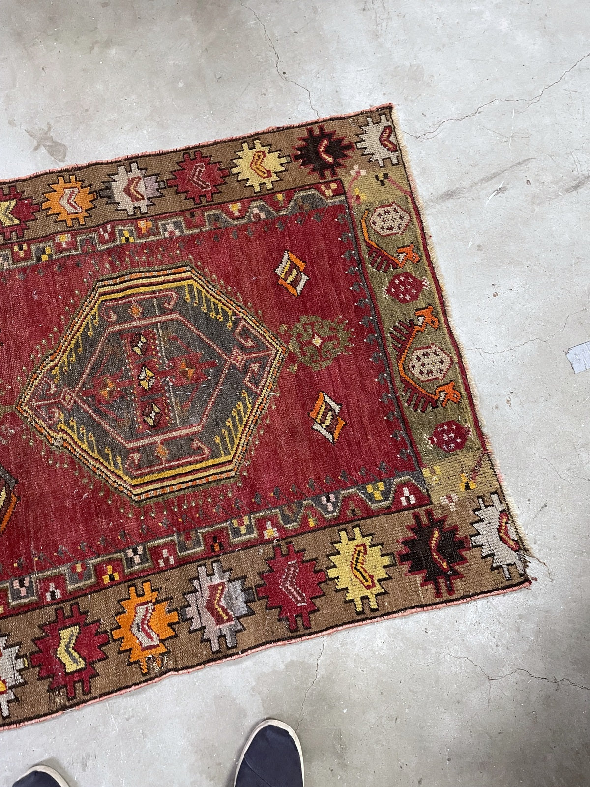 Dark hexagonal medallion with yellow and pink outlines beside a colourful serrated border.