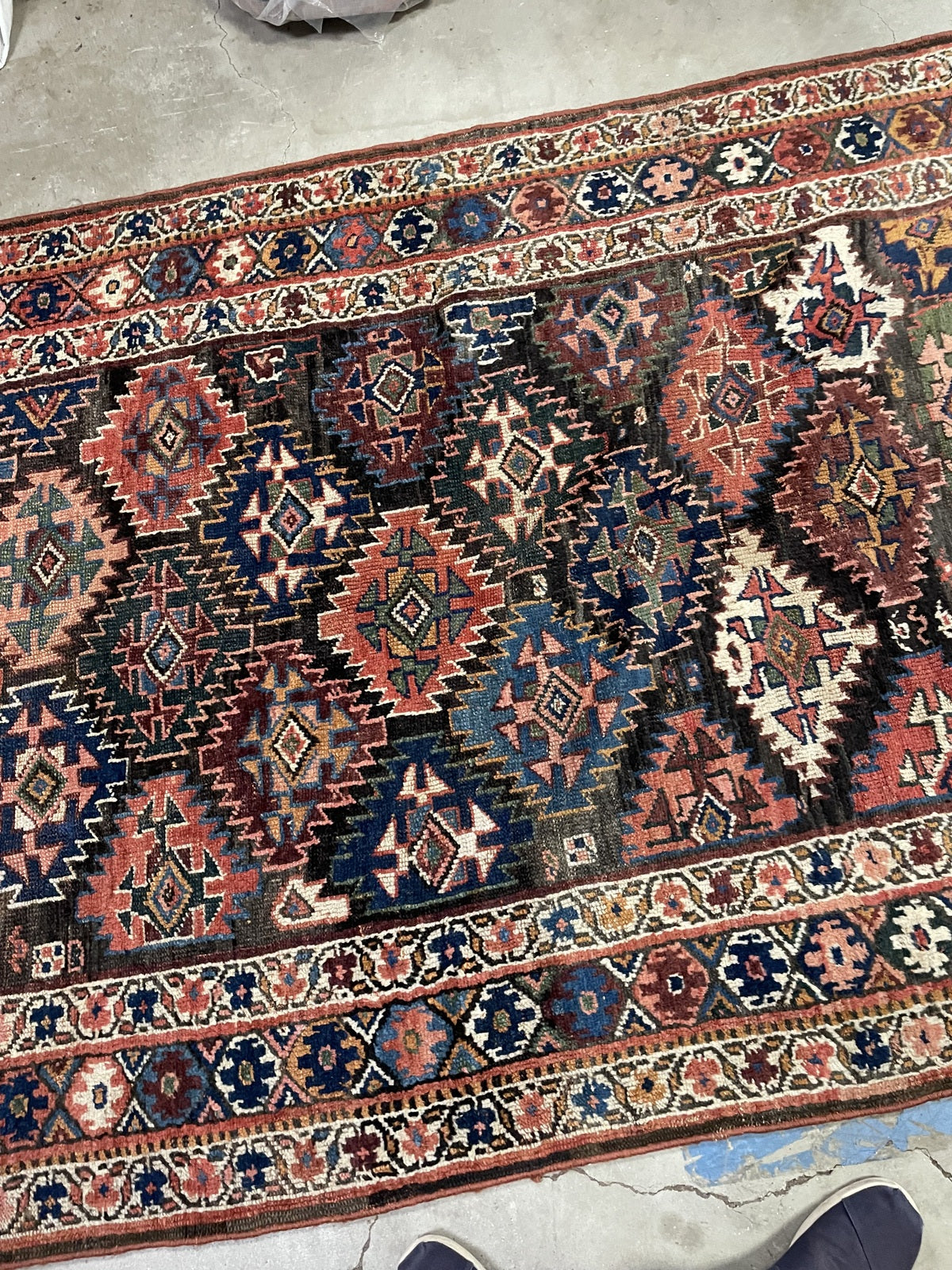 Angled rug corner showing layered rosette and scrolling floral borders.