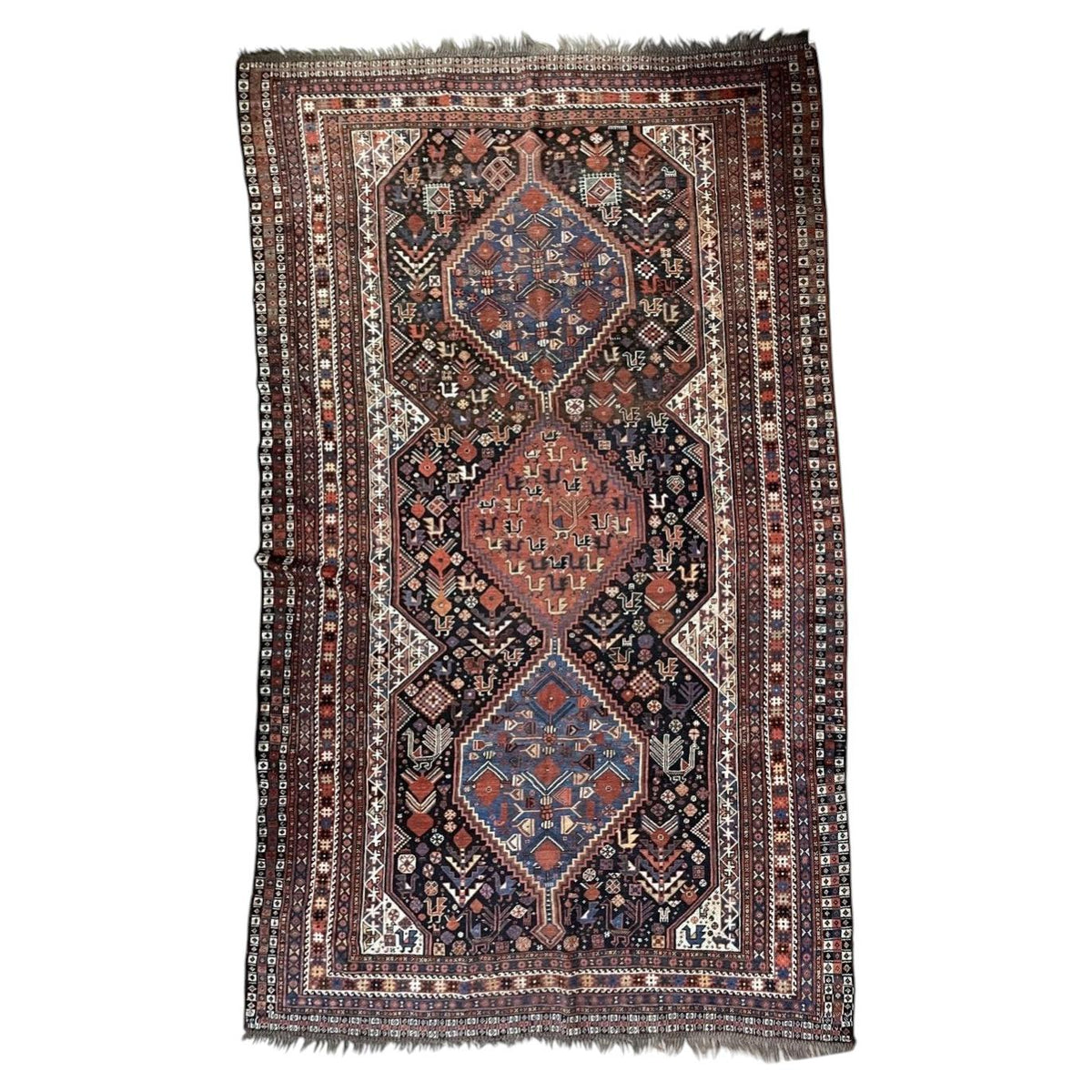 Full antique wool rug with three linked medallions, bird motifs and multiple narrow borders.