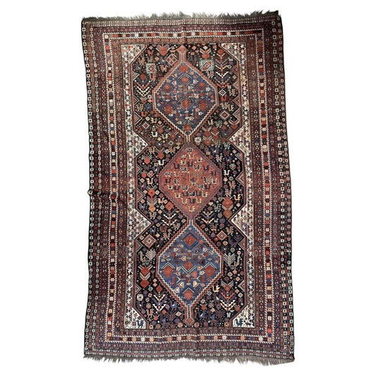 Full antique wool rug with three linked medallions, bird motifs and multiple narrow borders.