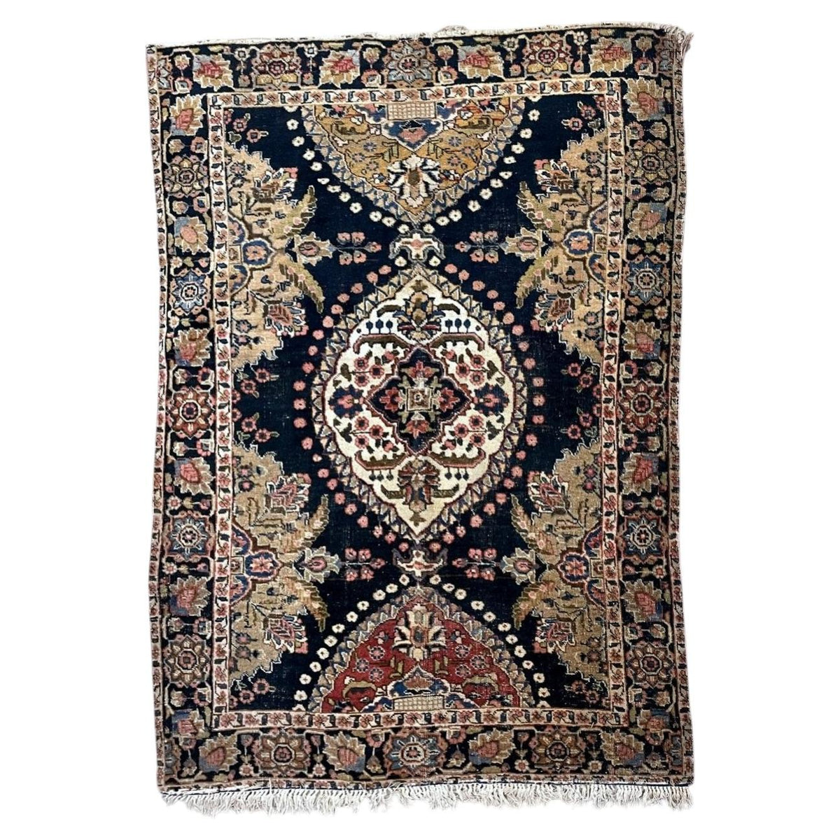 Full antique wool rug with ivory central medallion, navy field and contrasting red and ochre end panels.