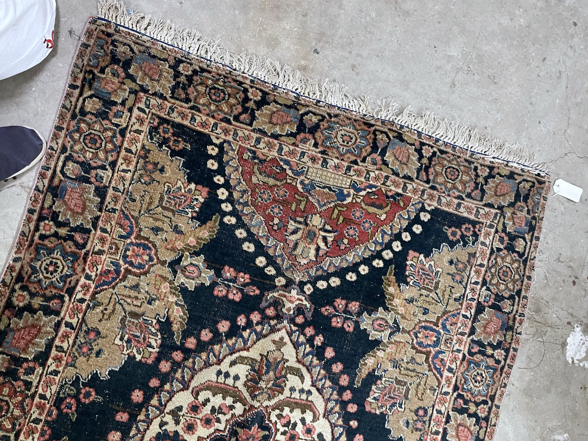 Angled full view showing scalloped botanical panels, floral borders and uneven fringes.