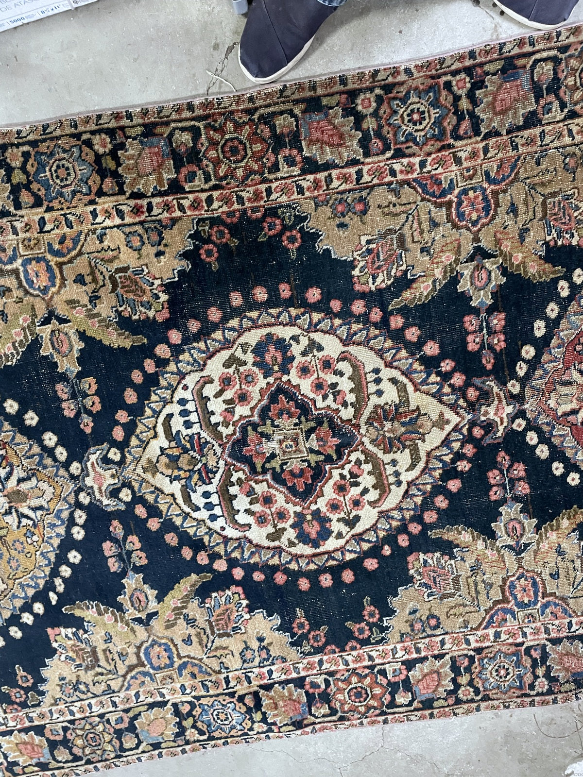 Red end panel with floral ornament, navy border and uneven ivory fringe remnants.
