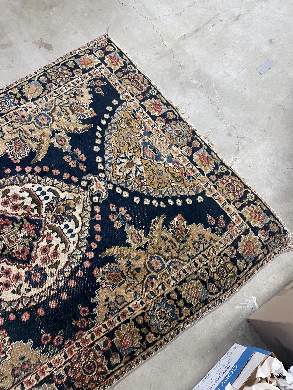 Angled view of the ivory medallion, navy field and worn gold-toned side panels.