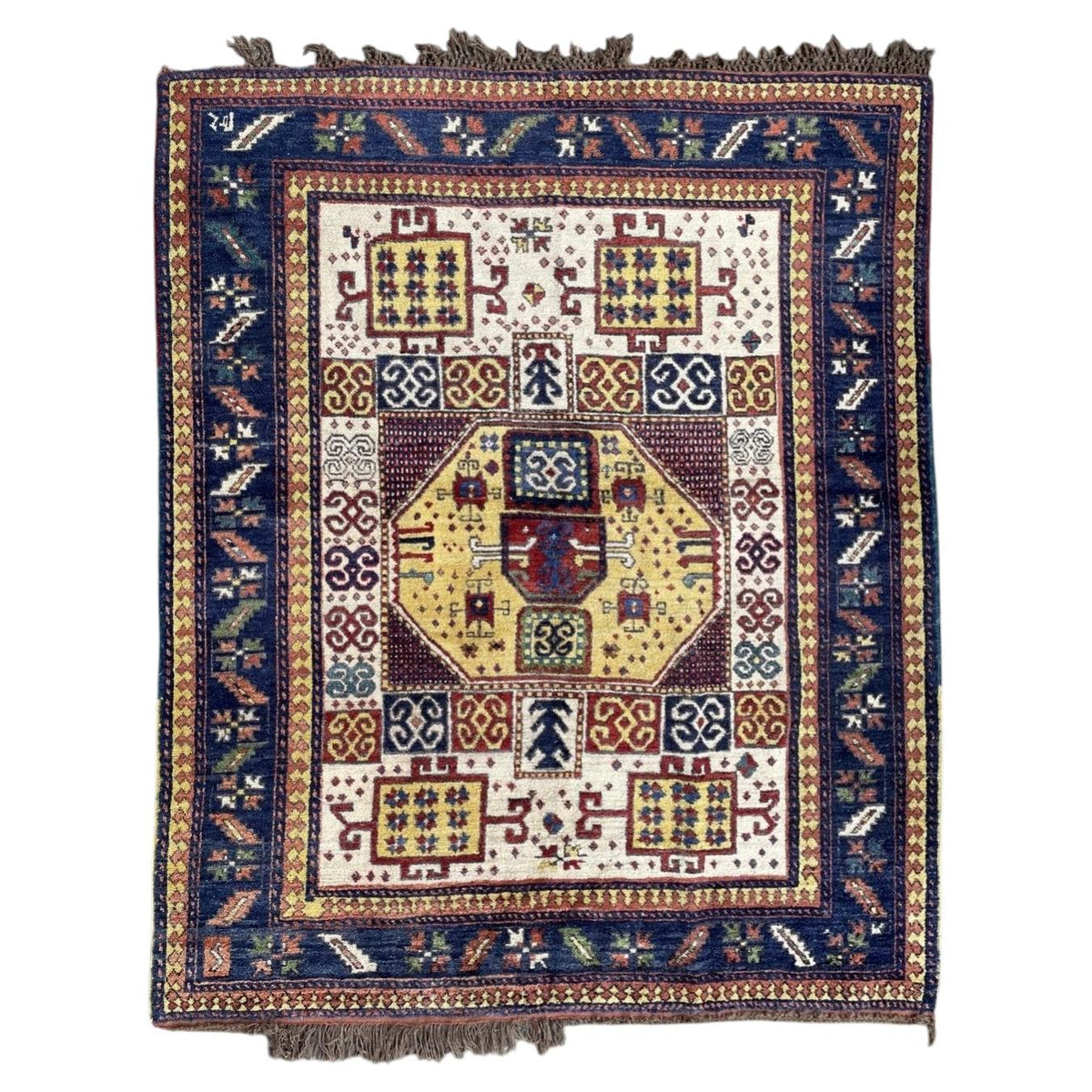 Full Armenian Karachov wool rug with yellow octagon, ivory field and broad navy geometric border.