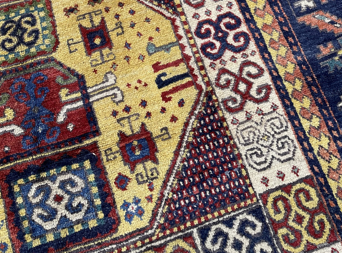 Yellow central field with contrasting square ornaments and dark patterned triangular sections.
