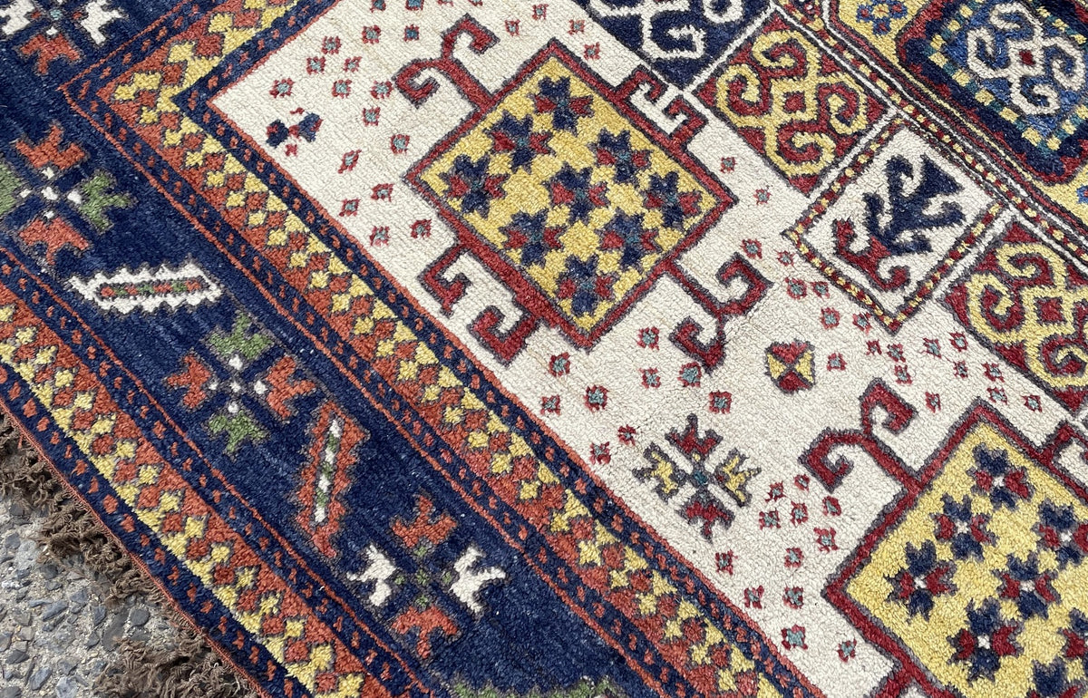 Corner detail with yellow square motifs, branching red outlines and scattered ivory-field ornaments.