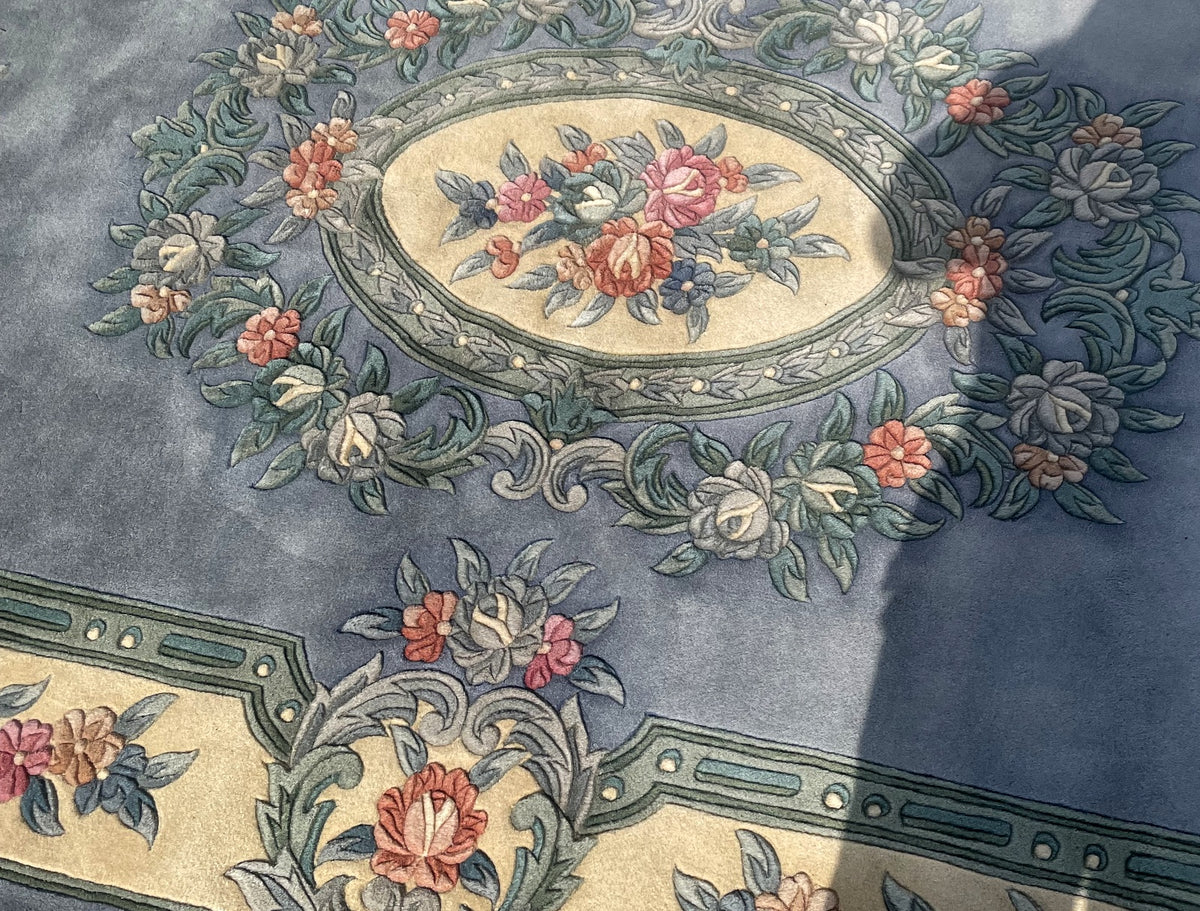 Ivory oval medallion filled with a colourful bouquet and surrounded by sculpted leafy scrolls.
