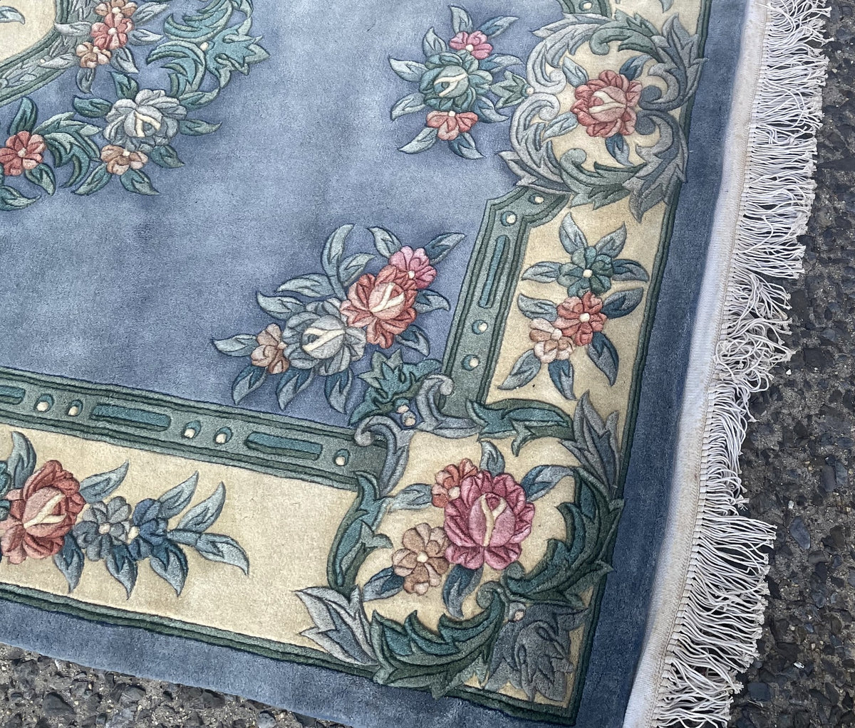 Angled view of the blue field, scattered bouquets and ivory floral border.
